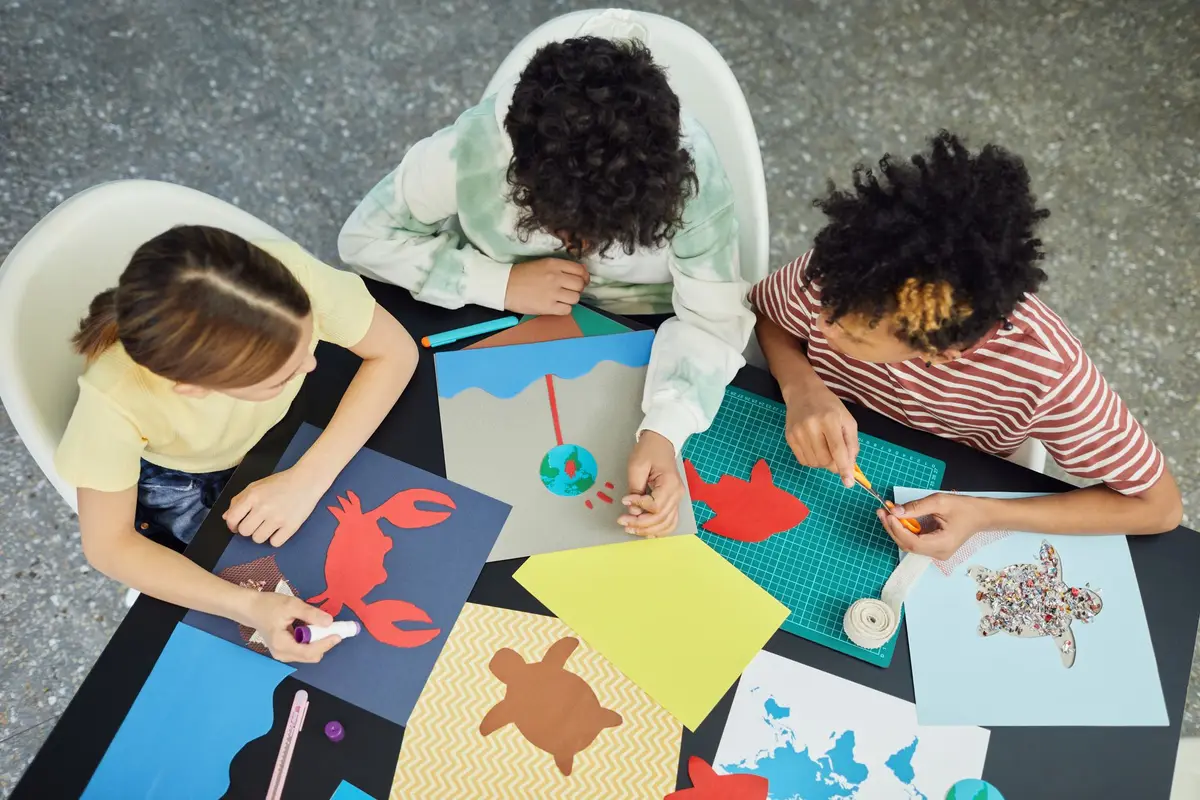 Groupe d'enfants réalisant des dessins et peintures ensemble lors d'un atelier